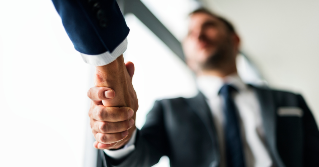 A close-up of a handshake between business professionals, symbolizing a strategic decision to outsource IT services.