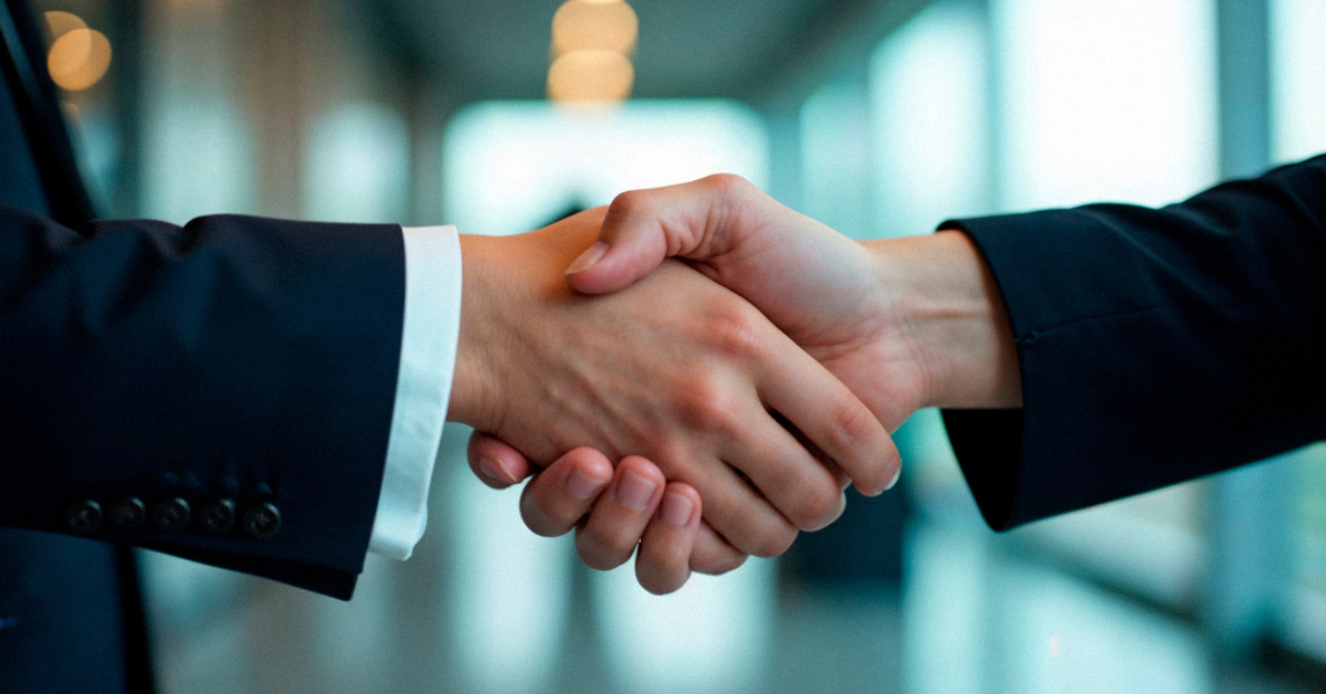Close-up of a business handshake in a corporate setting, representing a successful nearshore outsourcing agreement.