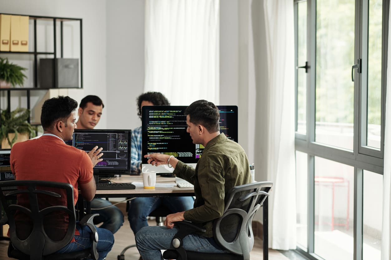 Team of IT professionals in an office working on computers - IT staff augmentation concept.