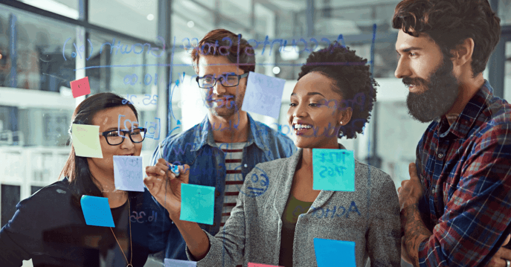 A diverse software team collaborating at a transparent board with sticky notes, planning tasks as part of an optimized SDLC process.