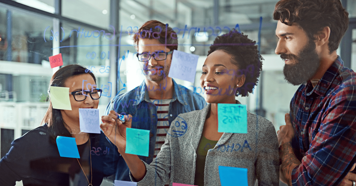 A diverse software team collaborating at a transparent board with sticky notes, planning tasks as part of an optimized SDLC process.