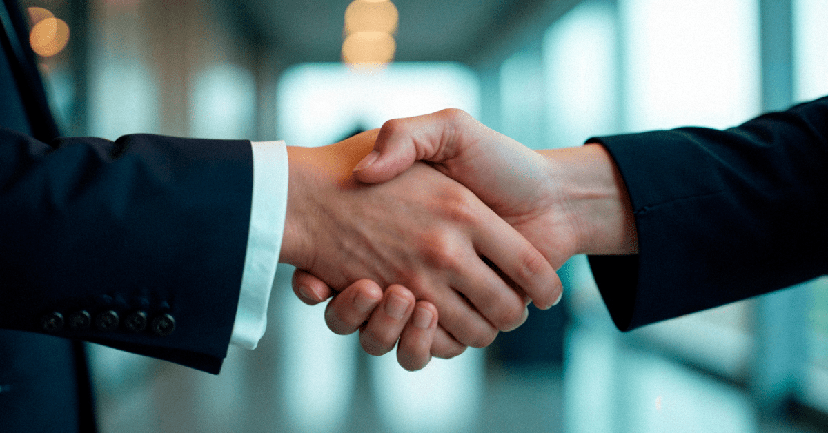 Close-up of a business handshake in a corporate setting, representing a successful nearshore outsourcing agreement.
