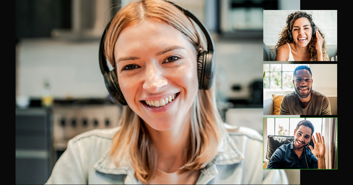 Woman smiling with headphones on, talking in a group video call with three other remote professionals.