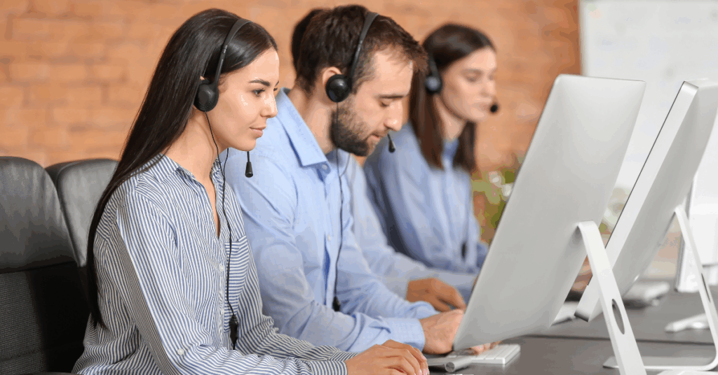 Focused Colombian customer support specialists working remotely on desktop computers.