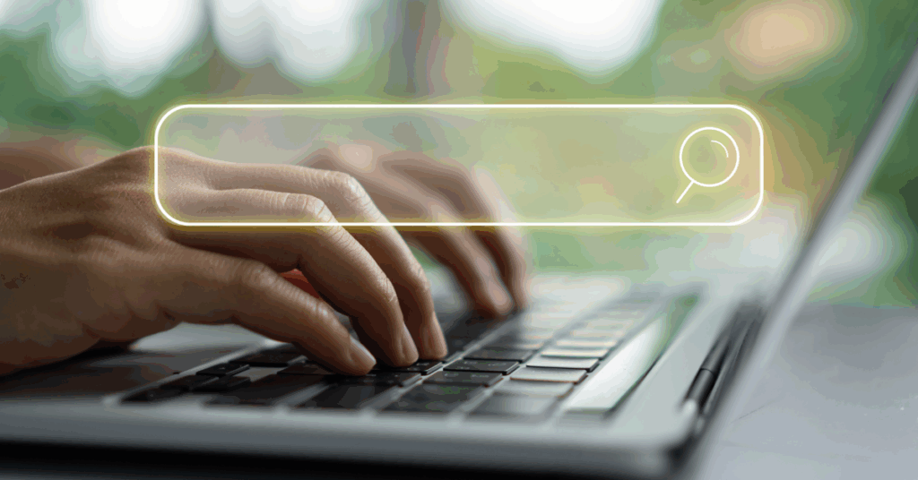 Hands typing on a laptop keyboard with a glowing search bar, symbolizing the search for trustworthy developer platforms beyond Fiverr.
