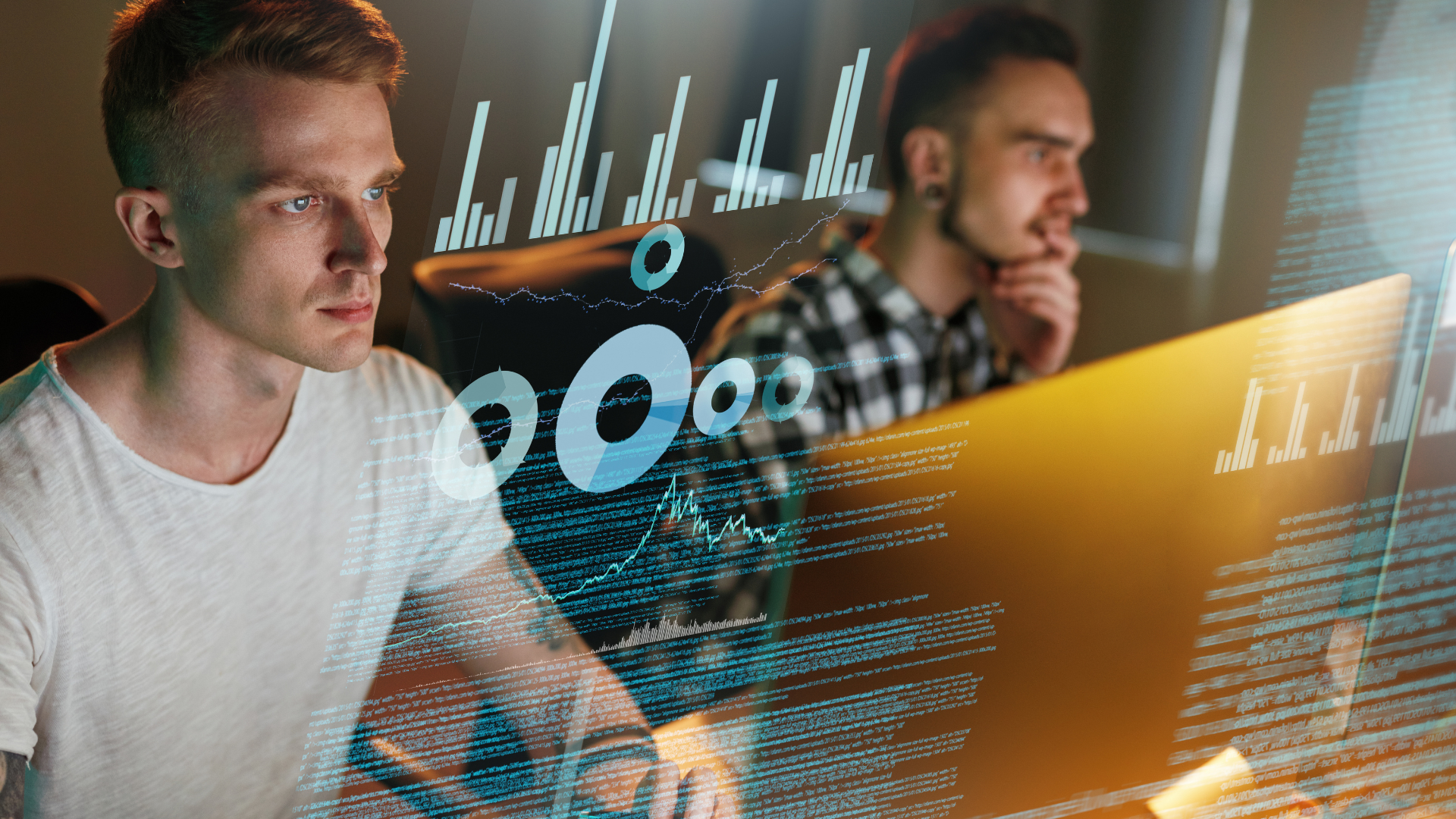 Two male software developers working on computers with overlaid digital charts and analytics data