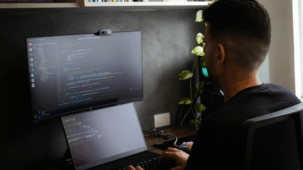Male software developer coding on dual screens in a home office setup, representing Mexico’s remote development talent.