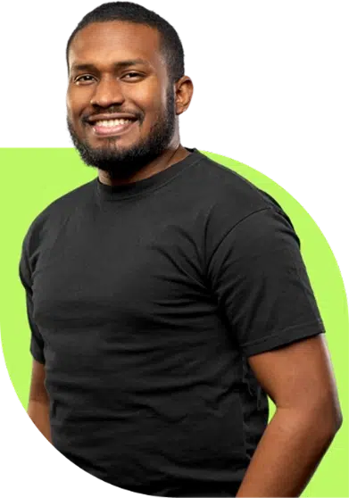 parallelstaff- A smiling man with a beard wearing a plain black t-shirt stands against a background with a light green shape.