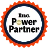 parallelstaff- A circular badge with a red scalloped edge and dark blue border featuring the words Inc. Power Partner in bold black and gold text.