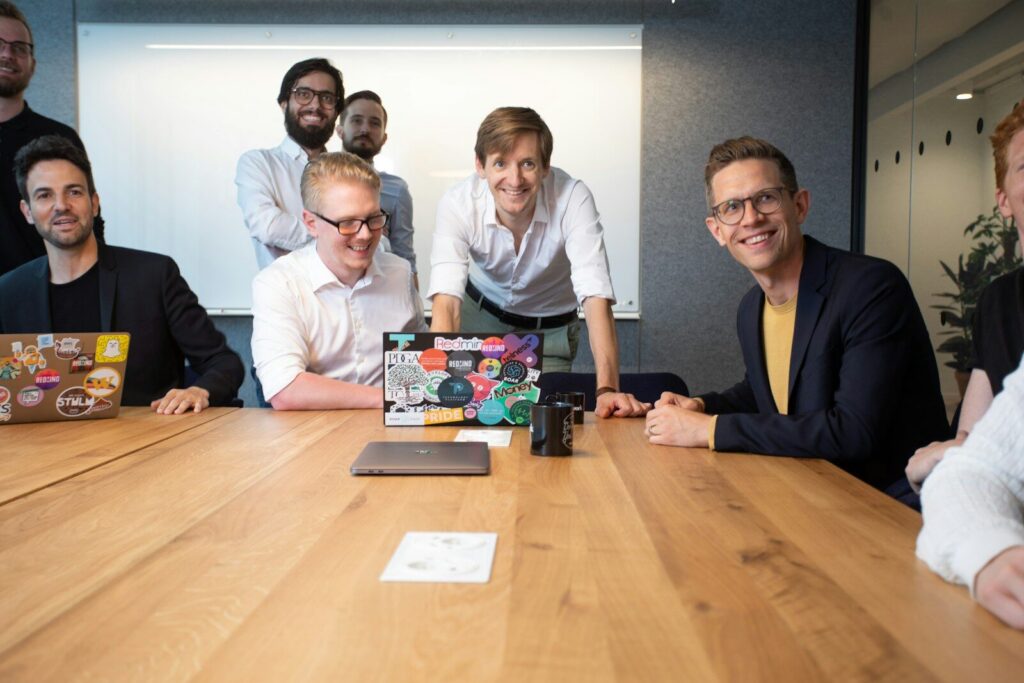 a group of people sitting around a wooden table